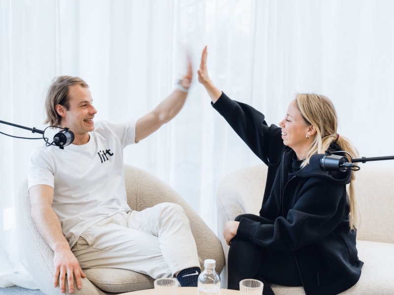 een man en een vrouw zitten in een zetel en zijn samen een podcast aan het maken met 50 koffies producties