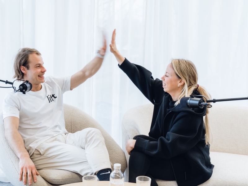een man en een vrouw zitten in een zetel en zijn samen een podcast aan het maken met 50 koffies producties