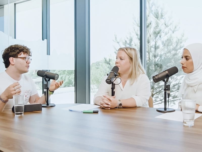 een man zit aan een tafel en wordt geïnterviewd door de zaakvoerders van 50 koffies producties