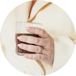 een vrouwenhand met een koffie in de hand wil graag een kennismakingsgesprek inplannen