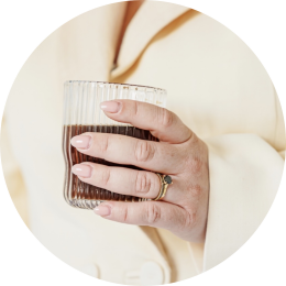 een vrouwenhand met een koffie in de hand wil graag een kennismakingsgesprek inplannen