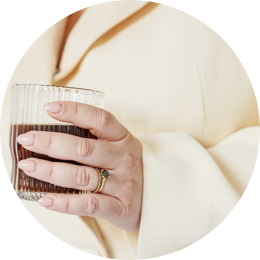 een vrouwenhand met een koffie in de hand wil graag een kennismakingsgesprek inplannen