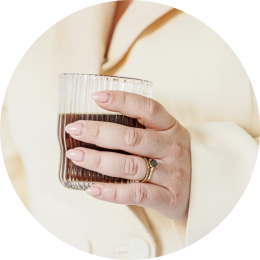 een vrouwenhand met een koffie in de hand wil graag een kennismakingsgesprek inplannen