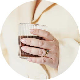 een vrouwenhand met een koffie in de hand wil graag een kennismakingsgesprek inplannen