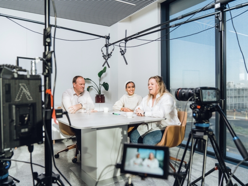 2 vrouwen zitten samen met een bedrijfsleider voor het maken van een podcast