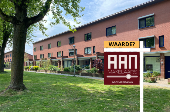 Straatbeeld van Drapenierlaan met 3-laags woningen met makelaarsbord van AAN op de voorgrond