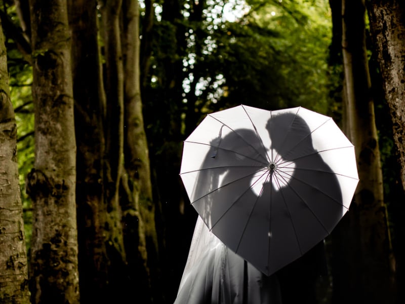 Bruidspaar achter een hartjes paraplu