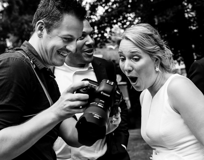 Bruidsfotograaf laat foto zien aan bruid