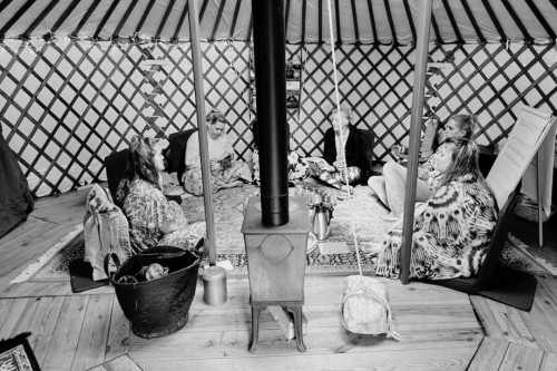 Een groep vrouwen in een yurt, zittend in een cirkel tijdens een training
