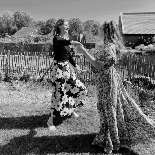 Twee vrouwen aan het dansen op het gras