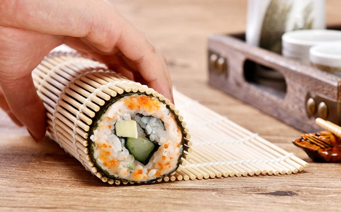 Sushi rolling using a sushi mat at the Japanese cooking class of Amsterdam Cooking Workshops