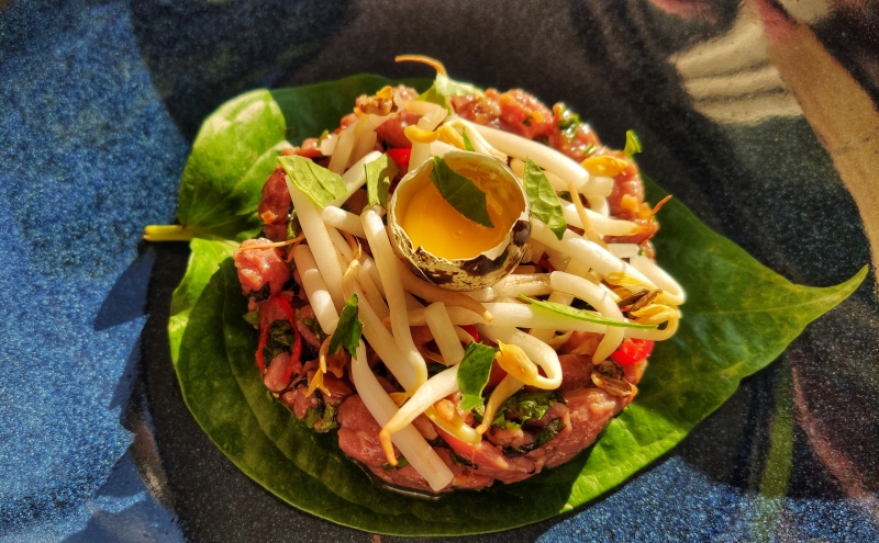Vietnamese steak tartaar op een blad en een blauw bord