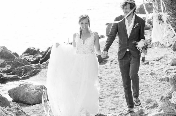 Annelies in trouwjurk op strand met echtgenoot