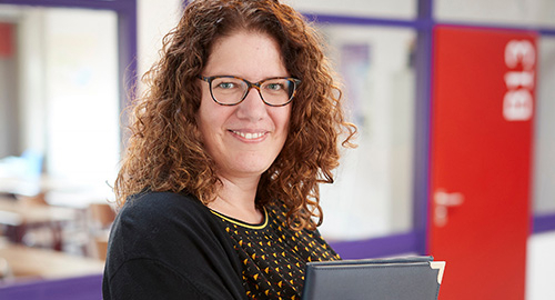 Cursist op school met op de achtergrond het klaslokaal van de cursus  basiskennis loonadministratie