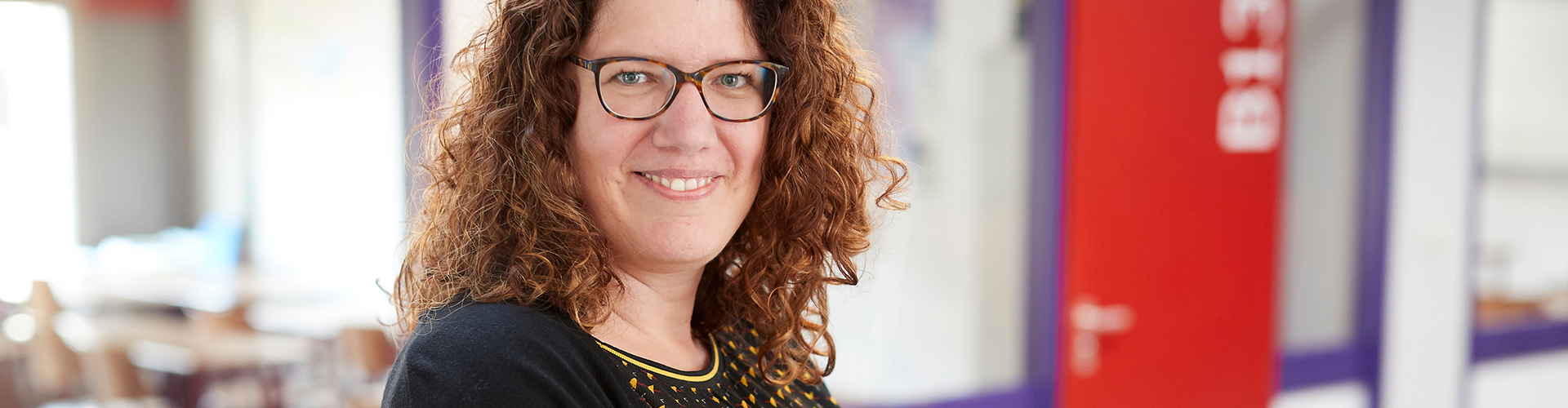Cursist op school met op de achtergrond het klaslokaal van de cursus  basiskennis loonadministratie