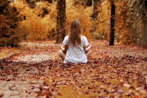 vrouw die zich ontspannen voelt en in het bos zit