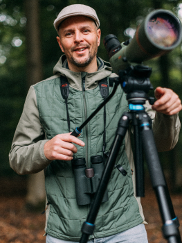 vogelwachter-adriaan-kowa-telescoop-naar-de-camera-kijkend