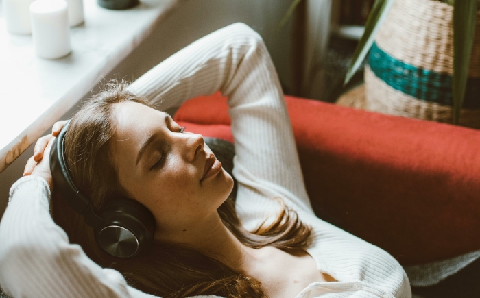 Vrouw luistert ontspannen naar de Deep Body Shift 3-daagse audio experience om uit haar hoofd te zakken en meer contact te maken met haar lichaam.