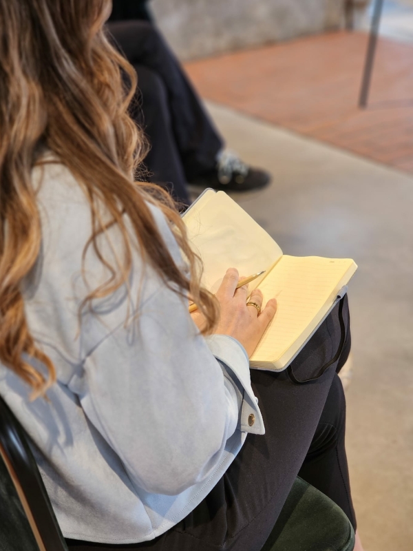 Deelnemer schrijft in een notitieboek tijdens een sessie bij Bloom by Mirte, met ruimte voor reflectie, bewustwording en verwerking.