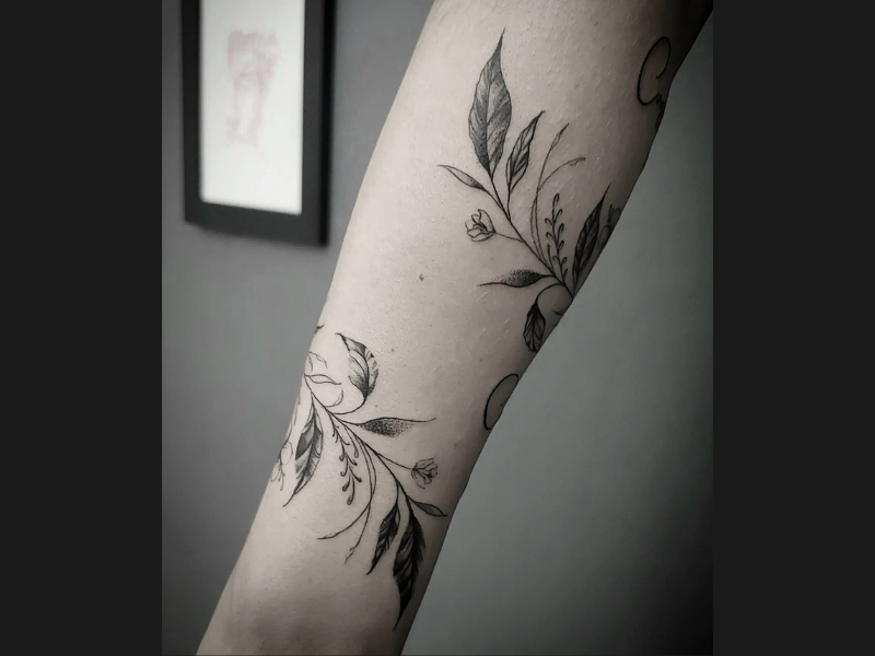 Fine line tattoo van bloemen en bladeren