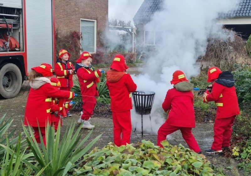 Kinderen blussen met echte brandweerslang tijdens brandweer kinderfeestje in Den Bosch