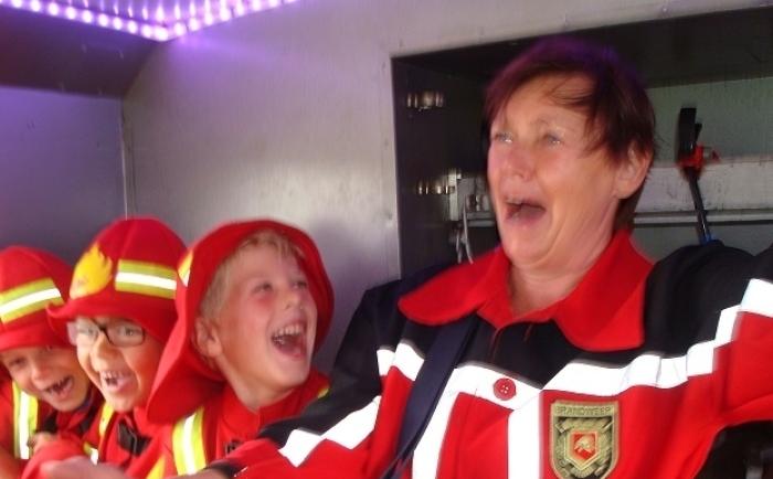 oma en de kleinkinderen lachen als we met de brandweerauto door de bocht gaan