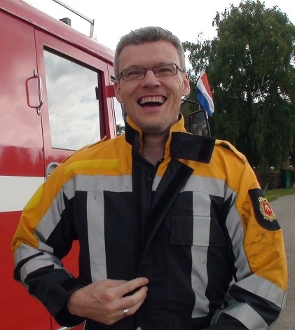 Vrolijke deelnemer bij de brandweerauto in Heerewaarden. Ons familiedag-arrangement in Gelderland combineert brandweeractiviteiten met een gezellige BBQ. Check beschikbaarheid.