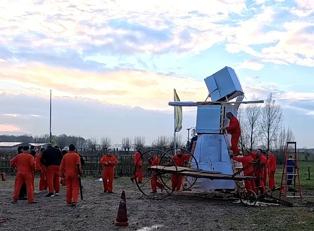 Team bouwt samen een reuzenpop tijdens een creatieve Burning Man workshop. Origineel bedrijfsuitje met vuur, teamwork en actie bij de brandweer.