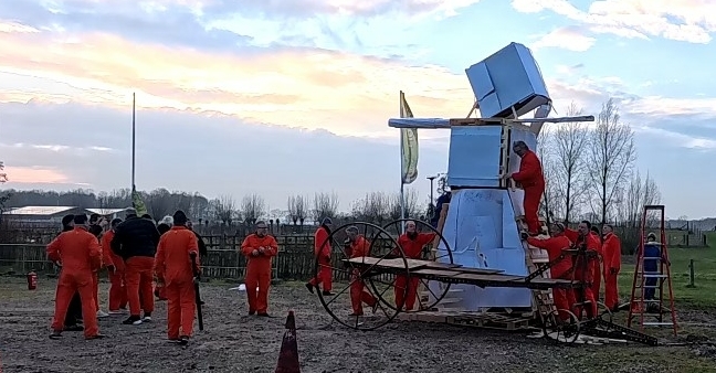 Team bouwt samen een reuzenpop tijdens een creatieve Burning Man workshop. Origineel bedrijfsuitje met vuur, teamwork en actie bij de brandweer.