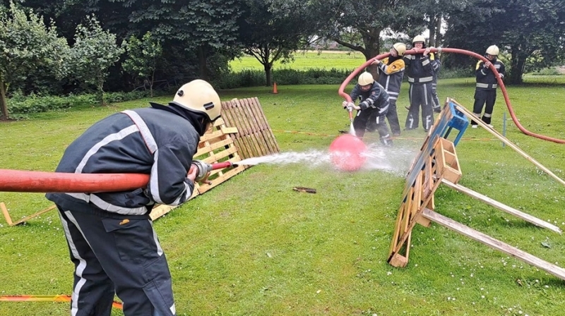 Teambuilding brandweer Gelderland met actief voetbalspel bedrijfsuitje Teambuilding bij de brandweer in Gelderland met teams die samenwerken tijdens een voetbalspel met brandslangen