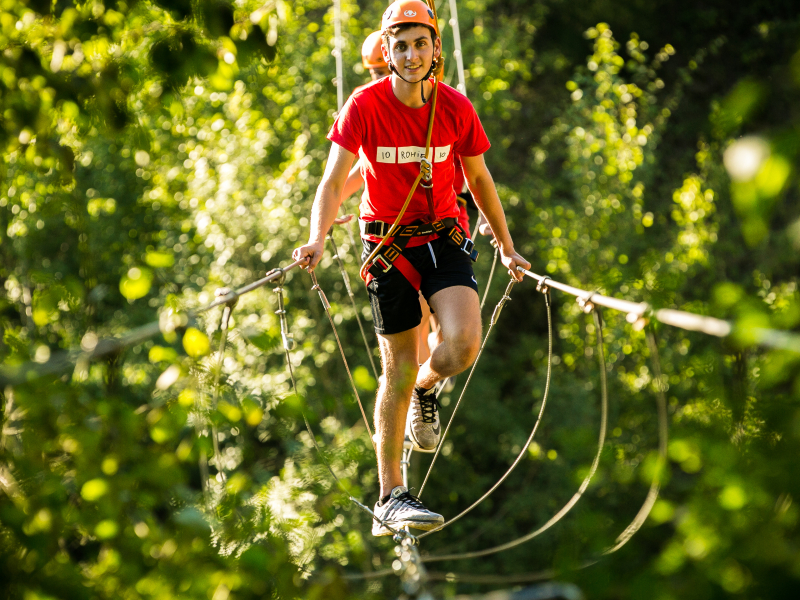 klauteren hoogteparcours jongen lachen blijdschap grenzen verleggen bomen bruggen