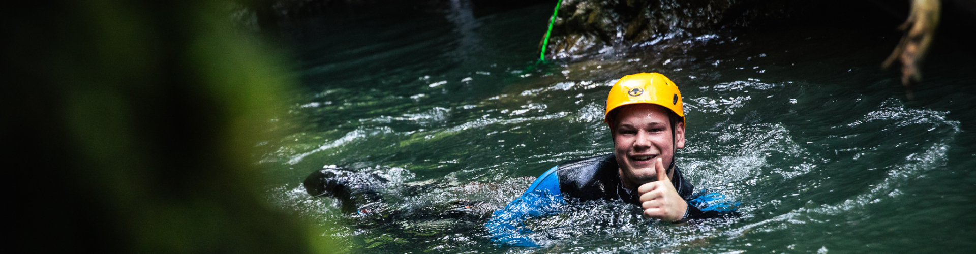 duimpje omhoog lachen jongen zwemmen canyoning