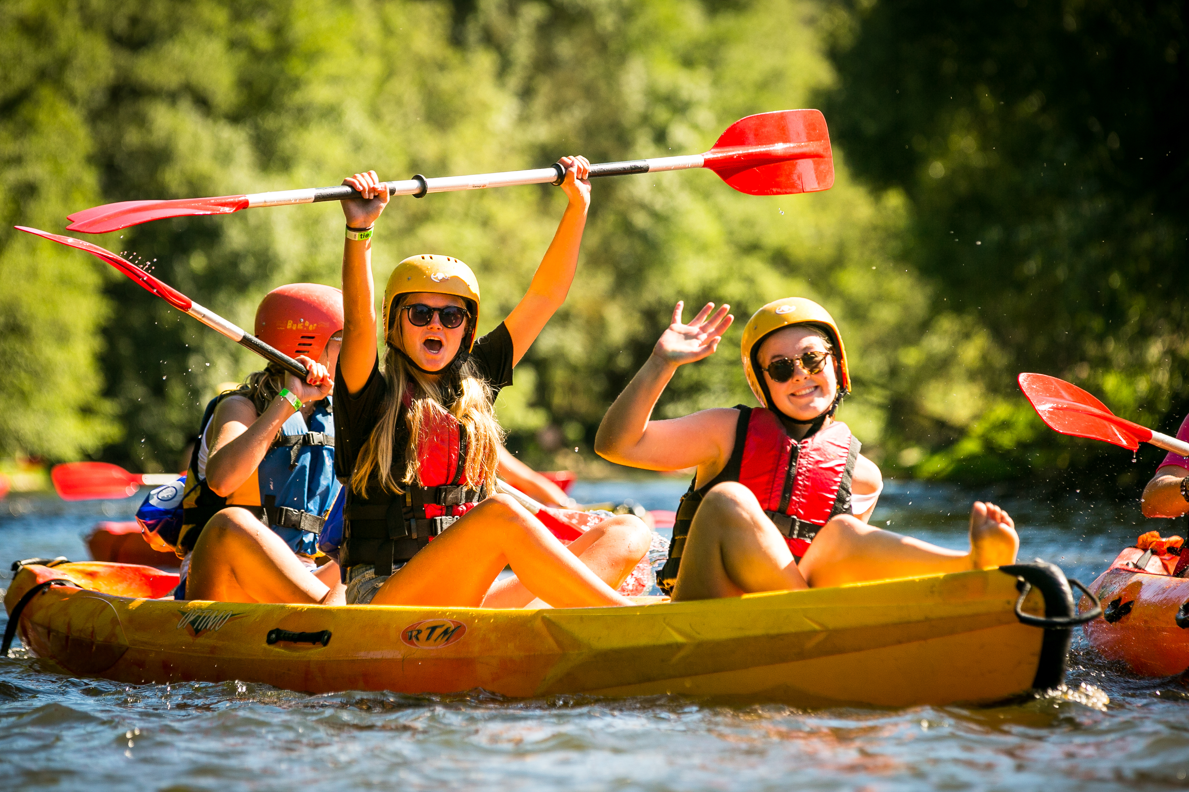 kanovaren peddelen water boot zwemvest outdoorkamp lachen enthousiast zwaaien