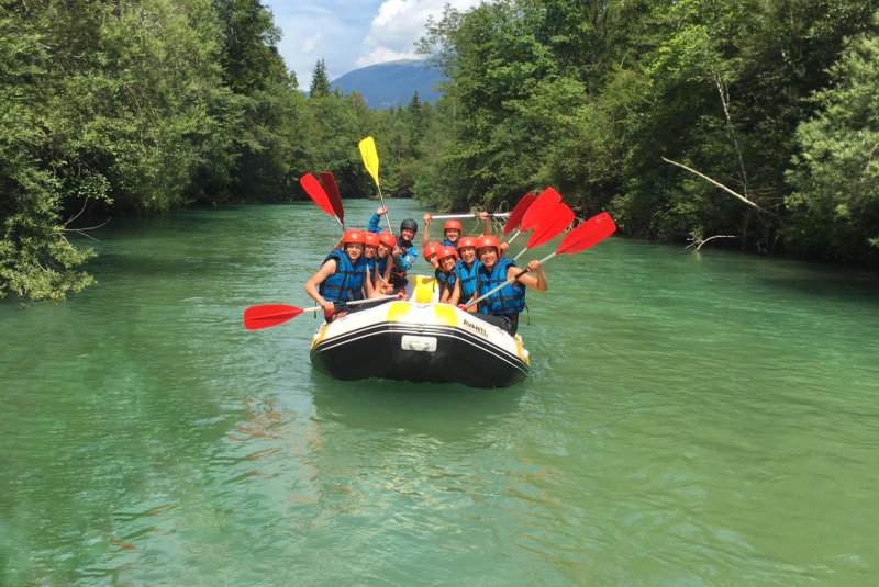 actieve reis kinderen peddels groepsfoto plezier lachen Slovenië raften rafttrip avontuur gezinsvakantie
