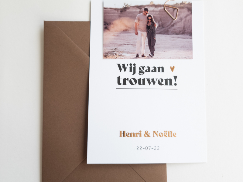 Henri en Noelle wij gaan trouwen trouwkaart zwart wit met koperfolie roséfolie en foto met paperclip alleen kaart dichtbij