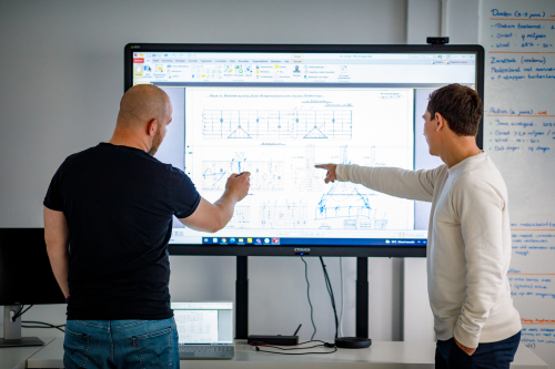 Twee constructeurs van ConstructieShop.nl bekijken samen op een groot scherm een constructieberekening.