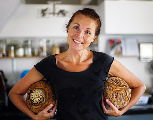 Marije Bakt Brood in de keuken met 2 broden onder de arm