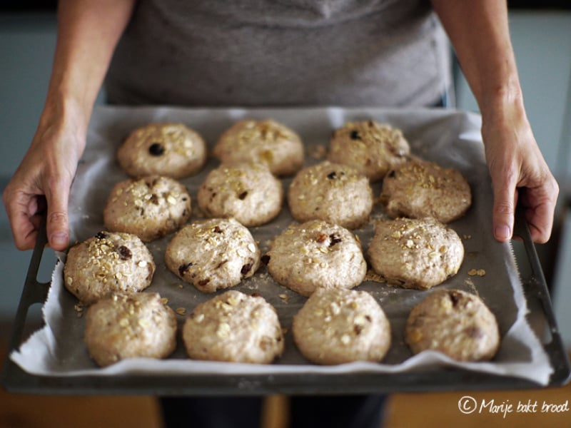 Zelf brood bakken - Gevulde mueslibollen klaar om gebakken te worden,  15 bolletjes handen met bakplaat