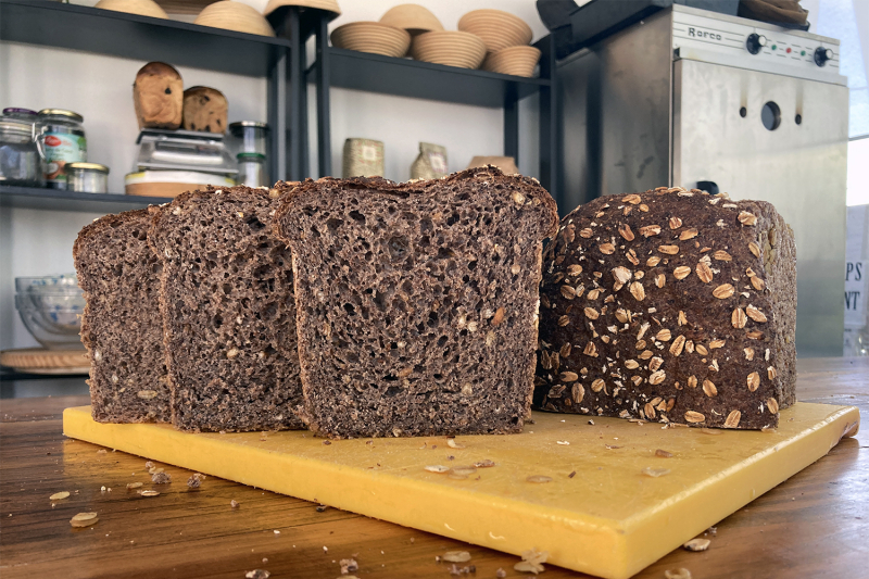 Volkoren meergranenbrood sneetjes- Marije Bakt Brood sneetjes op snijplank, bakoven haverkorrels bakkerij