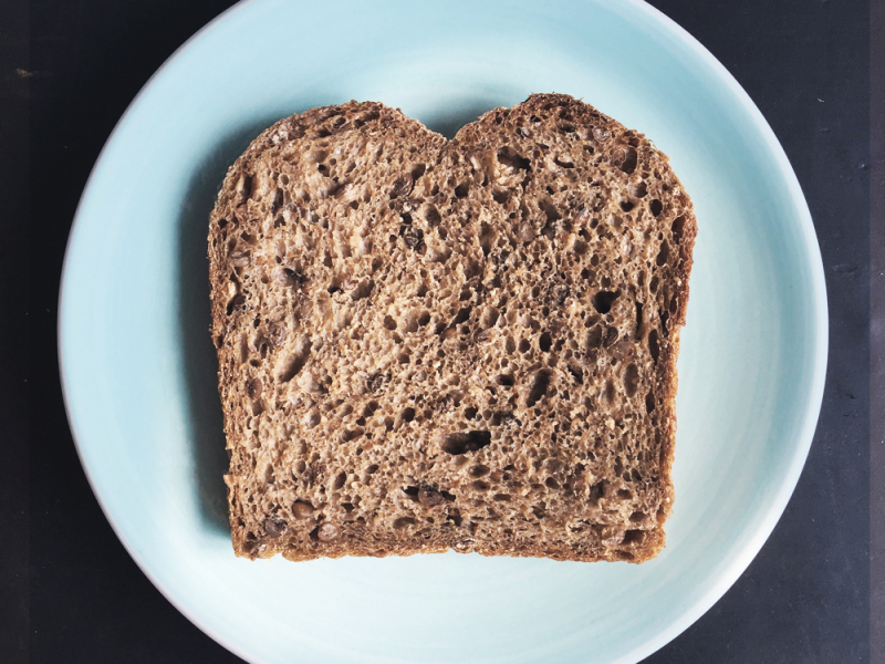 Volkorenbrood met hele korrel sneetje op bordp