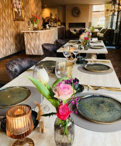 Luxe gedekte tafel met bloemen en kaarsen in het interieur van De La Frontière Bed & Borrelbistro in Slenaken