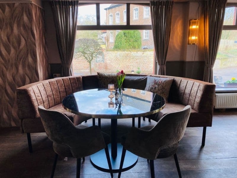 Gezellige zithoek met ronde tafel en uitzicht bij De La Frontière in Slenaken Limburg