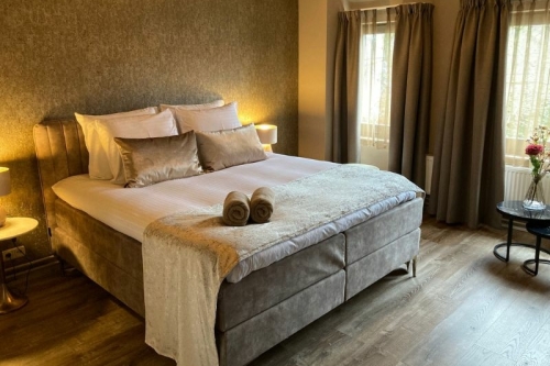 Sfeervol ingerichte hotelkamer met luxe boxspring, zachte handdoeken en natuurlijk licht bij De La Frontière Bed & Borrelbistro in Slenaken