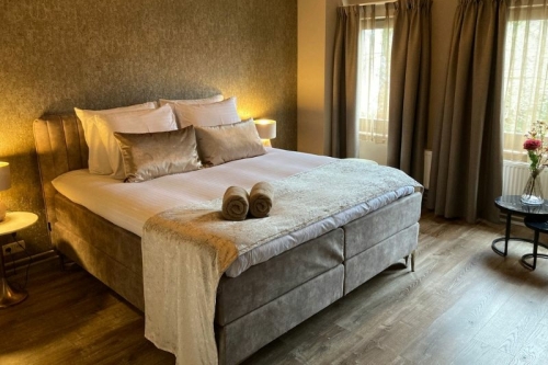 Sfeervol ingerichte hotelkamer met luxe boxspring, zachte handdoeken en natuurlijk licht bij De La Frontière Bed & Borrelbistro in Slenaken