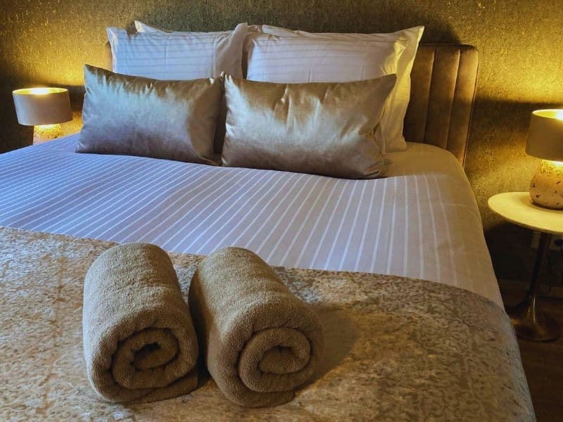 Comfortabele hotelkamer met groot bed en zithoek bij De La Frontière in Slenaken