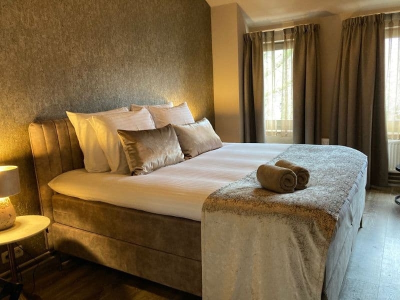 Luxe tweepersoonskamer met comfortabel bed en warme verlichting bij De La Frontière in Slenaken