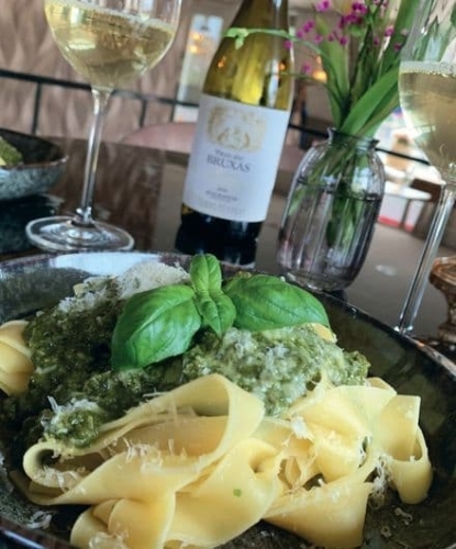 Pasta Verdi met courgette-spinaziesaus en parmezaan geserveerd met een glas wijn bij De La Frontière Bed & Borrelbistro in Slenaken