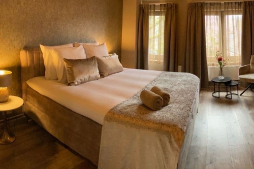 Stijlvol ingerichte hotelkamer met luxe boxspring en warme sfeerverlichting bij De La Frontière Bed & Borrelbistro in Slenaken