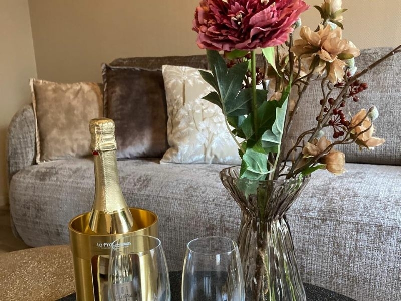 Sfeervolle zithoek in de suite van De La Frontière met champagne op ijs en verse bloemen bij Bed & Borrelbistro in Slenaken