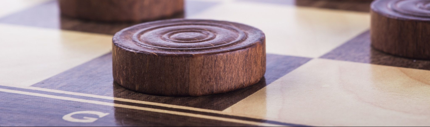 Gezellige speelruimte op Holland America Line met een selectie bordspellen, comfortabele stoelen en uitzicht op zee.